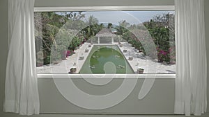 View from the hotel room to calm tropical resort with garden and pool. Background Plate, Chroma Key Video Background