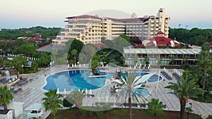 View of hotel with swimming pools and palm trees.