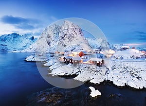 View on the house in the Hamnoy village, Lofoten Islands, Norway. Landscape in winter time during blue hour. Mountains and water.