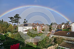 View of houses and gardens in southern Dublin with beautiful rainbow captured from a window during coronavirus lockdown, Dublin