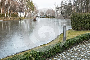 View of the ice-covered winter lake in the park.