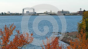 View of iconic Duluth Minnesota Aerial Lift Bridge, water and shore of Lake Superior in autumn.