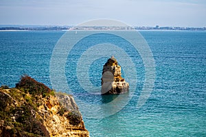 View of idyllic nature landscape with rocky cliff shore and waves crashing on