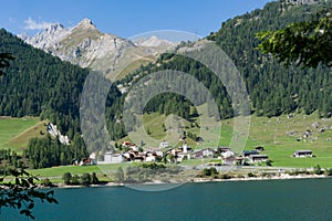 View of an idyllic and picturesque turquoise mountain lake surrounded by green forest and mountain peaks in the Swiss Alps