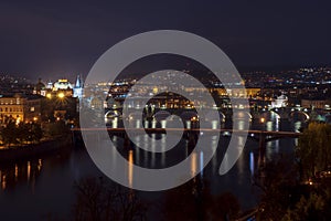 view of illuminated bridges on the Vltava river in the center of Prague at night at czech republic