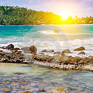 View of an Indian Ocean lagoon with tropical vegetation on the shore, a sandy beach and a coral reef