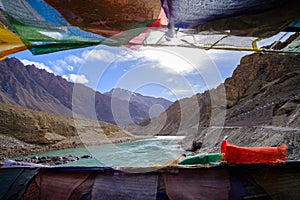 View of Indus River and mountains from bridge with colourful mantra flags