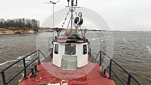 View from the industrial boat with a barge sailing behind. Clip. Concept of water transportation of goods.