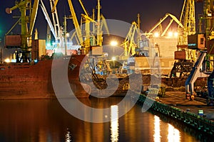 View of the industrial port at night - ships waiting for loading and unloading, cargo transportation by sea