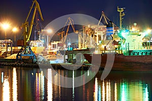 View of the industrial port at night - ships waiting for loading and unloading, cargo transportation by sea