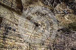 View inside the ancient cave with stone walls with additional lighting. Texture of a stone wall in a cave