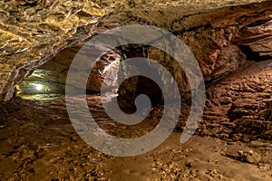 View inside the ancient cave with stone walls with additional lighting. Texture of a stone wall in a cave