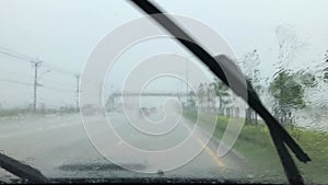 View from inside a car driving on the road in heavy rain.