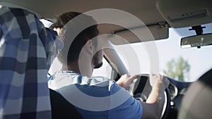 View inside car. Young man traveling by car through country road.