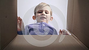 View from inside of the cardboard box little blonde boy cardboard box being opened