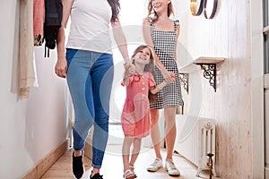 View Inside Hallway As Same Sex Female Couple With Daughter Open Front Door Of Home