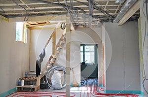 A view from inside the house under construction with fiberglass insulated ceiling, indoor electric wiring in metal conduit,