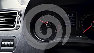 View inside of a passenger car with a dashboard. Action. Close up of engine speed scale with rising arrow, concept of