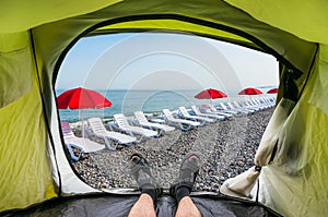 View from inside a tent on the sun loungers on a beach