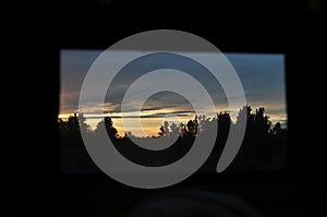 View from inside the train car to the beautiful natural landscape of sunset and trees. local train travel. selective focus