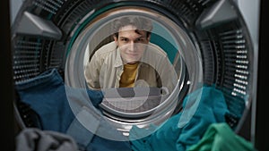 View from inside the washing machine, adult man looking at the camera and smiling