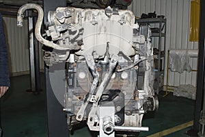 View from the intake manifold side of the assembled car engine installed on the engine repair stand