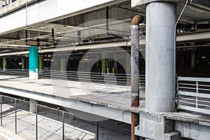 View into interior of an empty parking garage with pipes and chain link fencing