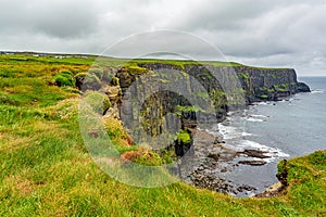 View of the Irish countryside and rocky cliffs along the coastal walk route from Doolin to the Cliffs of Moher