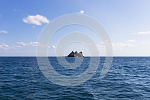 View of  island called Sveta Nedelja St. Sunday near Petrovac, Montenegro and blue sky with white fluffy clouds