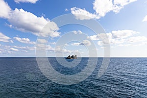 View of  island called Sveta Nedelja St. Sunday near Petrovac, Montenegro and blue sky with white fluffy clouds