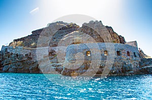 View of the island of Spinalonga with calm sea. Here were isolated lepers, humans with the Hansen`s desease, gulf of Elounda.