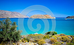 View of the island of Spinalonga at sunset with nice clouds and calm sea.