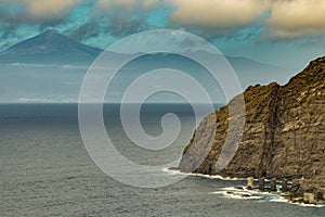 View of the island of Tenerife from Santa Catalina beach. Huge concrete piers for davit and the ruins of the old Hermigua port. La