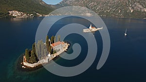 View of the islands of Perast and a yacht sailing near them in the Bay of Kotor