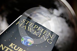 View on isolated  book cover of Stephen Hawking with blurred world globe background