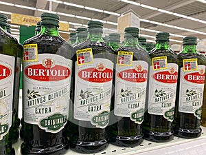 View on isolated italian Bertolli olive oil bottles in shelf of german supermarket