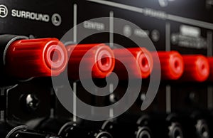 View on isolated red speaker outputs in a row of back side of black dolby surround home cinema receiver