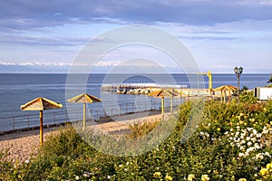 View of Issyk-Kul Lake, a beach with View of Issyk-Kul Lake with parasols and lawns with flowers