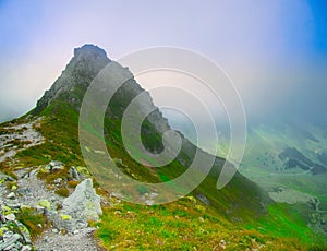 View on jagged mountain of Zillertal alps on a foggy summer day