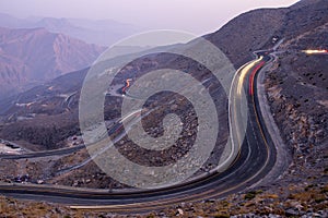 View from Jebael Jais mountain of Ras Al Khaimah emirate in the evening. United Arab Emirates, Light trails from the car