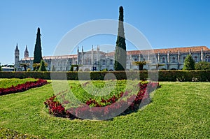 The view of Jeronimos Monastery through the beautiful garden of Empire square. Lisbon, Portugal