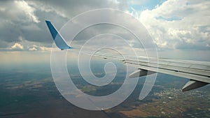 View of jet airplane wing shaking from air turbulence while flying through dark storm clouds. Travel and air