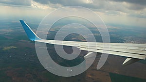 View of jet airplane wing shaking from air turbulence while flying through dark storm clouds. Travel and air