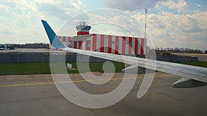 View of jet airplane wing taxiing runway after landing at airport. Travel and air transportation concept.