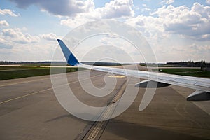 View of jet airplane wing taxiing runway after landing at airport. Travel and air transportation concept