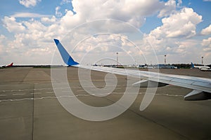 View of jet airplane wing taxiing runway after landing at airport. Travel and air transportation concept