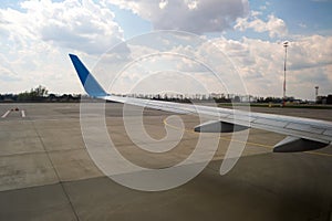 View of jet airplane wing taxiing runway after landing at airport. Travel and air transportation concept