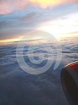 View of Jet engine and Clouds or sunset from inside the plane.