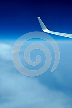 View of jet plane wing on the background of clouds