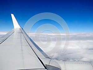 View of jet plane wing on the background of thick clouds